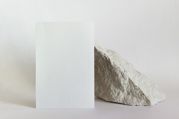 Mockup template with white card and stone on white background