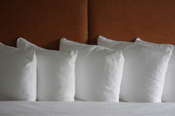 Close view of white pillows on a freshly made hotel bed 