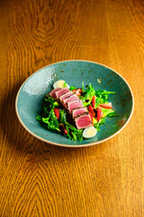 Sliced steak with blood. on a blue plate