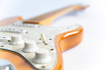 Detail of an electric guitar close up. White and blurry.

