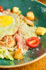 Fototapeta na wymiar Caesar salad with large fried eggs