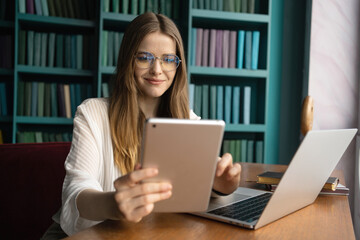 Female freelance designer in office coworking space working workplace uses laptop computer