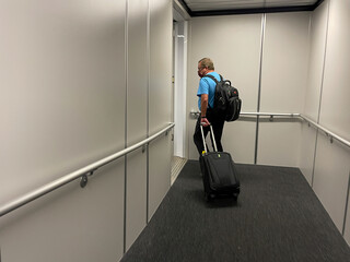 A man walking in the jetway to board an airplane at an airport.