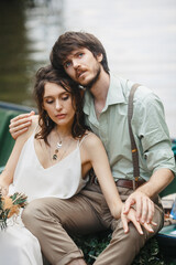 Couple in love near a wooden boat on the river bank.Calmness, meditation, retro style. Exciting moments of love