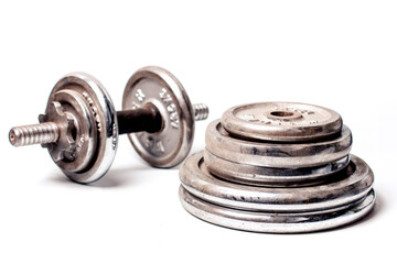old dumbbells and discs for dumbbells on a white background