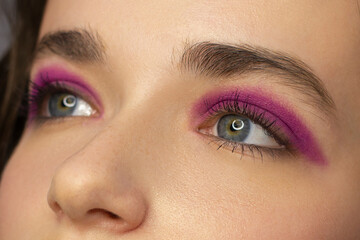 Cosmetics and make-up. Beautiful female eye with sexy pink liner makeup. Fashion big arrow shape on...