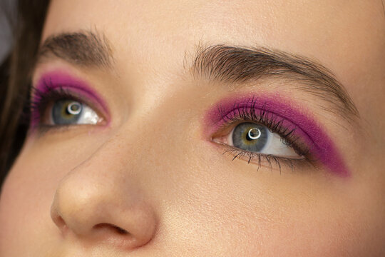 Cosmetics and make-up. Beautiful female eye with sexy pink liner makeup. Fashion big arrow shape on woman's eyelid. Chic evening make-up