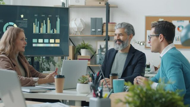 Group of employees male and female talking discussing project working in modern office together. Conversation and business development concept.