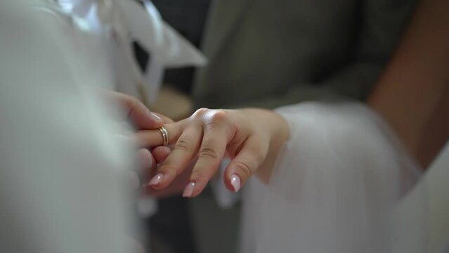 An unrecognizable bride and groom wedding rings exchanging rithual in the church during the christian wedding ceremony