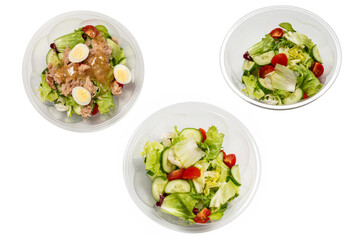 Fresh tuna salad with lettuce, cucombers, cherries and eggs in plastic container.