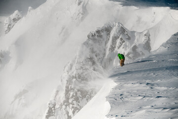 Man skier with climbing equipment fixed himself with a safety rope