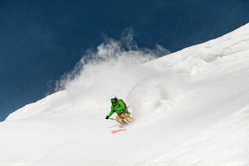 Young man skier running down the slope in the Carpathian mountains.