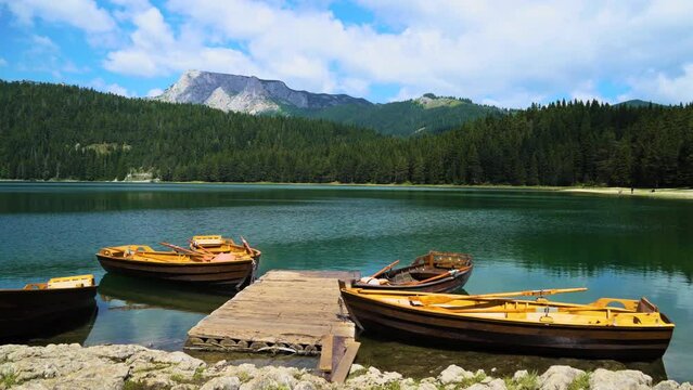Montenegro. Zabljak. Durmitor National Park. Popular tourist spot. Pier with wooden rowing boats on the Black Lake. Panorama. The camera moves from left to right