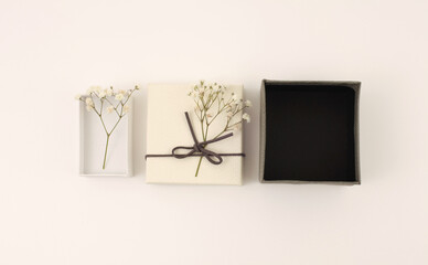 Craft gift boxes with flower on light beige wall copy space background. Minimalism style template background. Flat lay, top view.