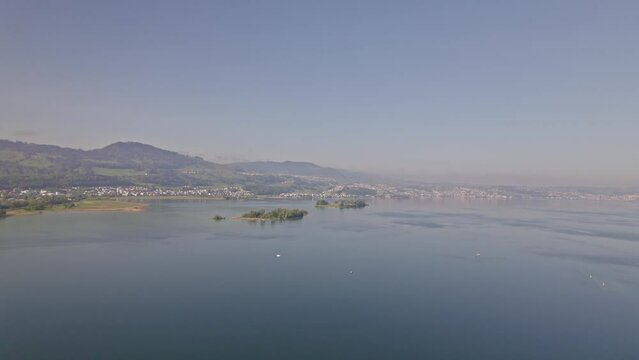Aerial view over Zürich Lake from City of Rapperswil-Jona, Canton St. Gallen, with Islands Lützelau and Ufenau in the background. Movie shot April 28th, 2022, Rapperswil-Jona, Switzerland.