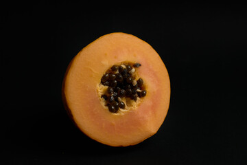papaya cut in half with black background