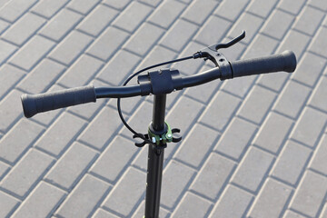 Scooter handlebar with hand brake on tile background, scooter rental