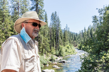 Senior man in woods with mask off