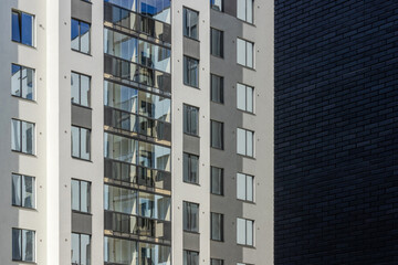 View of a multi-storey high-rise residential building in the metropolis through a brick wall of black  

