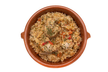 Chicken rice stew served in a clay bowl, isolated on white background. Spanish food concept.