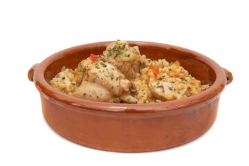 Chicken rice stew served in a clay bowl, isolated on white background. Spanish food concept.