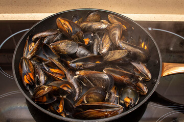 Cooking mussels in a pan. Mussels are perfect in endless fish recipes, but the simplest and most traditional in Galicia are steamed mussels.