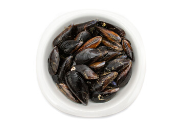 Raw mussels in a white bowl, isolated on white background. It feeds on phytoplankton and zooplankton, and even decomposing organic particles found in seawater, by filtering it through its gills.