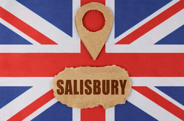 On the flag of Great Britain lies a symbol of geolocation and cardboard with the inscription -...