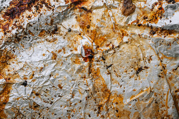 Background, texture, top view of dirty, greased, sunflower oil, after cooking a meat dish, colored foil. Food photography.