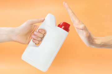 Man rejecting to take a white jerry can with red cap on an orange background. Machine. Plastic....