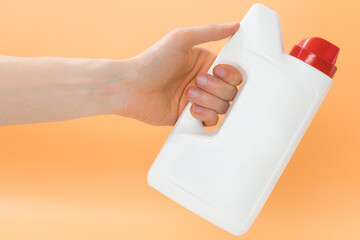 Man holds a blank white jerry can with red cap on a yellow background. Gallon. Home. Dishwashing....