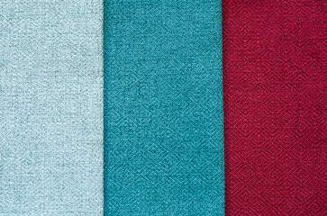 Fototapeta premium Grey, blue, red background. set of multi-colored dense fabrics of uniform texture. choice of materials in different colors. vertical fragments.