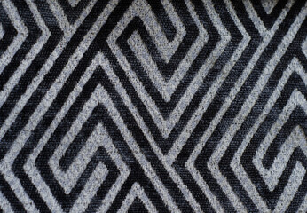 abstract geometric pattern on  fabric, black lines and rhombuses on  gray background.