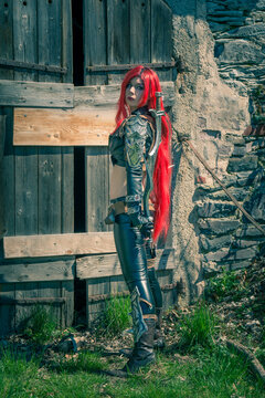 Woman with long red hair in a medieval costume with dagger