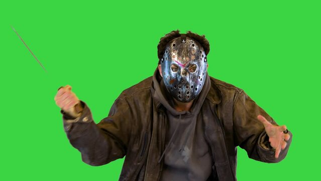Insane maniac in metal mask with man eyes slaughter victim with machete knife Angry madman fighting on a Green Screen, Chroma Key.