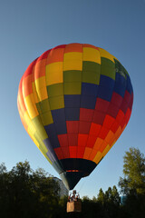 Obraz premium moment of takeoff of colorful hot air balloon from the ground