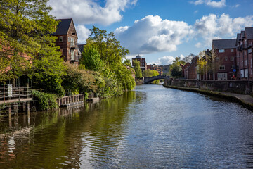 Fototapeta na wymiar A view along the developed River Wensum on a bright and sunny morning