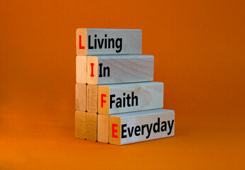 LIFE living in faith everyday symbol. Concept words LIFE living in faith everyday on wooden blocks...
