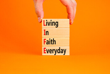 LIFE living in faith everyday symbol. Concept words LIFE living in faith everyday on wooden blocks...