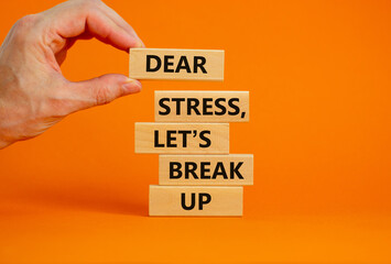 Stress break up symbol. Concept words Dear stress let is break up on wooden blocks. Businessman hand. Beautiful orange background. Business motivational stress break up concept. Copy space.