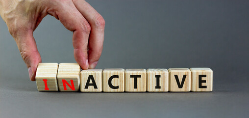 Active or inactive symbol. Businessman turns wooden cubes and changes the word Inactive to Active....