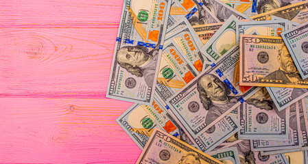 Dollars on a pink wooden background. Money on the table. American dollars.