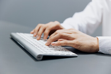 businessmen hands on keyboard office work close-up Gray background
