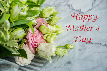 Minimal composition with a Eustoma flowers and next Happy mother's day on marble background,side view. mothers day greeting card.copy space