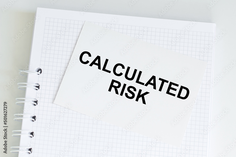 Aufkleber business concept. calculated risk text on a card that sits on a notebook on a light table