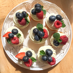 Home made cupcakes with cream and fresh berries. freshly baked desserts.