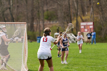 SEWICKLEY, PA, USA - APRIL13th 2022: Teenage girls from Sewickley Academy play senior school varsity lacrosse game against Freeport High School. There were lots of goals and action on this sunny day.