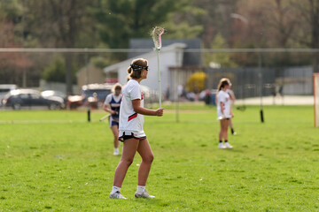 SEWICKLEY, PA, USA - APRIL13th 2022: Teenage girls from Sewickley Academy play senior school varsity lacrosse game against Freeport High School. There were lots of goals and action on this sunny day.