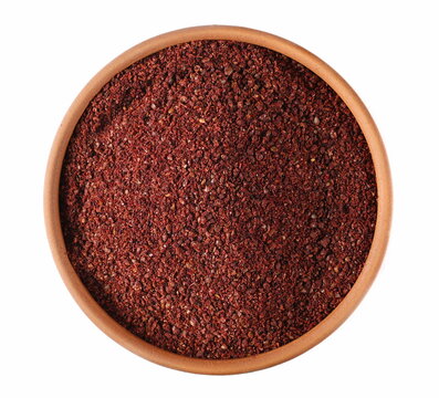 Ground sumac spice, pile in clay pot isolated on white, top view 