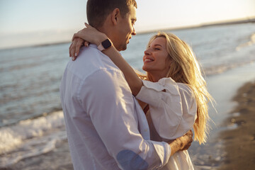 Obraz premium Portrait of happy couple hugging while standing on beach